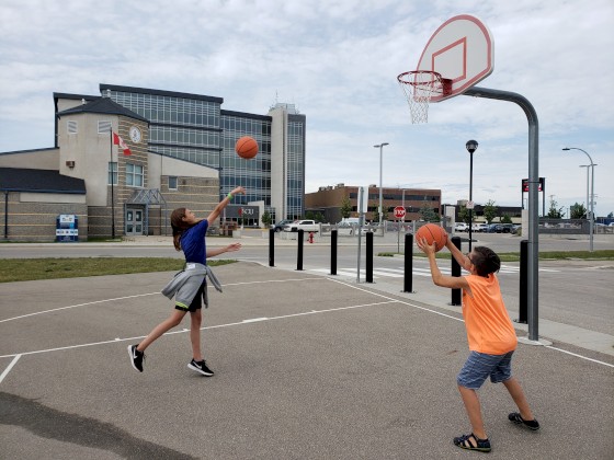Campers playing basketball at the Steinbach Community Plaza.