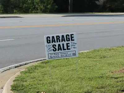 Signage promoting a garage sale on a boulevard.