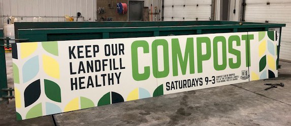 A Community Compost Bin with a large sign across its side that reads, 