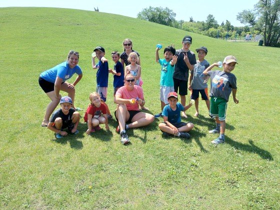 Campers and camp director posing with water balloons.