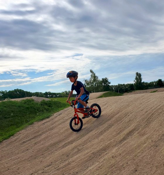 Camper riding a bmx bike down the track.