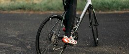 Biker peddling a bike. Photograph is cropped to show only the bike and the biker's lower body.