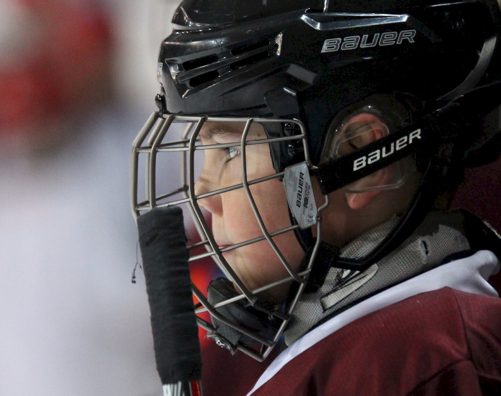 Young hockey player watches the ice.